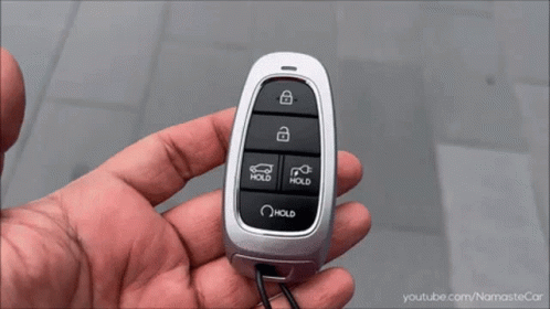 A Close Up Of A Hand Holding A Car Key With The Word Hold On It GIF