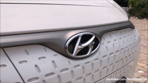 A Close Up Of A Hyundai Logo On The Front Of A White Car GIF