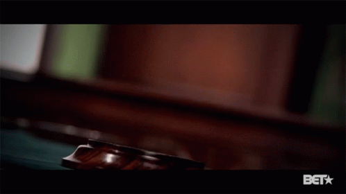 A Close Up Of A Judge 'S Gavel With A Bet Logo Below It GIF