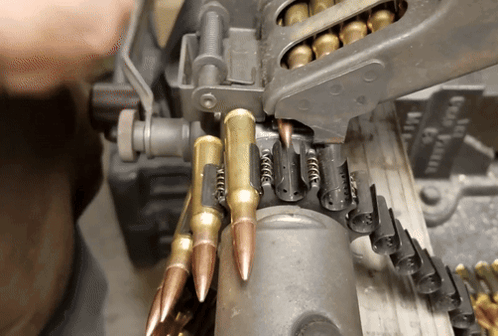A Close Up Of A Machine With Bullets Coming Out Of It And A Sign That Says Good Grain GIF