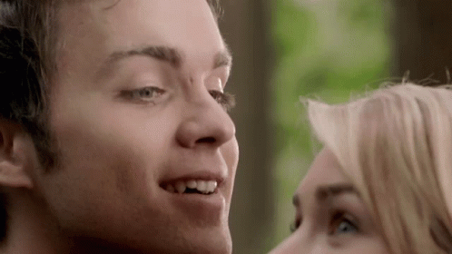 A Close Up Of A Man And A Woman 'S Faces Looking At Each Other GIF