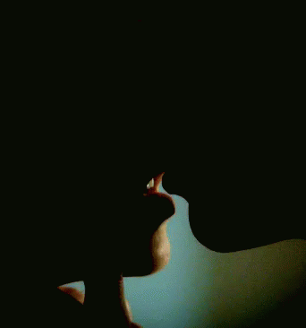 A Close Up Of A Man And Woman Kissing Each Other In The Dark . GIF