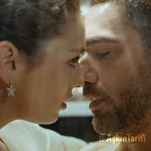 A Close Up Of A Man And Woman Kissing With Askin Tarifi Written On The Bottom Right GIF