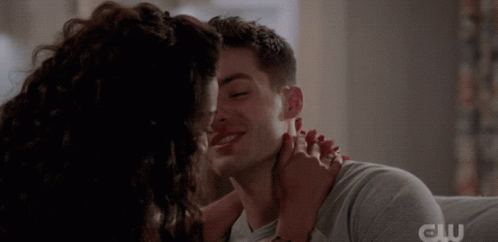 A Close Up Of A Man And Woman Kissing With The Cw Logo In The Corner GIF