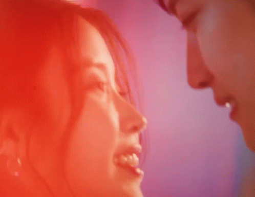 a close up of a man and woman kissing with their eyes closed