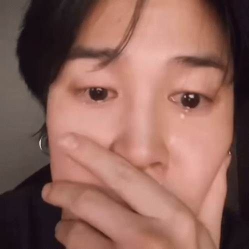 A Close Up Of A Man Covering His Mouth With His Hand . GIF