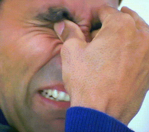A Close Up Of A Man Covering His Nose With His Hands GIF