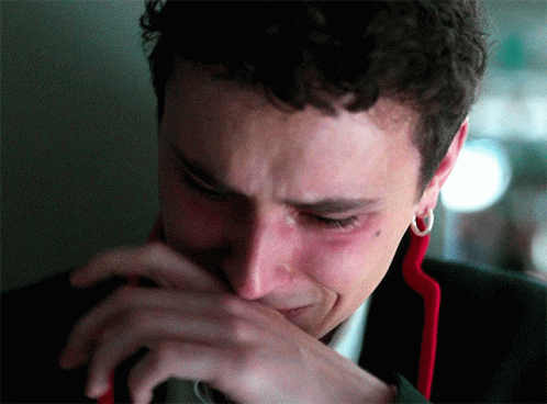 A Close Up Of A Man Crying With His Hand Over His Mouth GIF