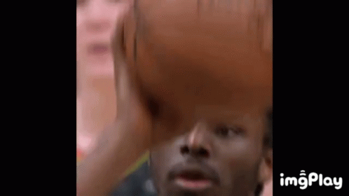 A Close Up Of A Man Holding A Basketball Over His Head GIF