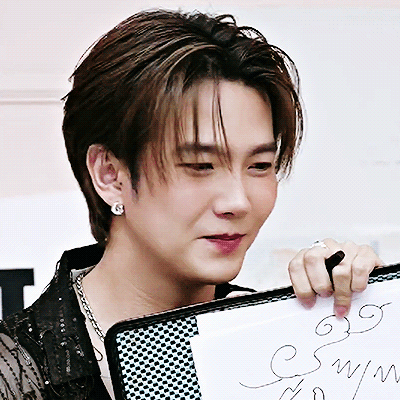A Close Up Of A Man Holding A Piece Of Paper That Says ' Symph ' On It GIF