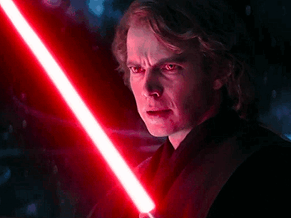 A Close Up Of A Man Holding A Red Lightsaber In His Hand . GIF