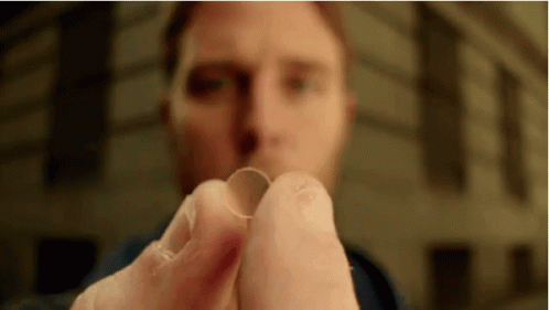 A Close Up Of A Man Holding Two Contact Lenses In His Hands . GIF