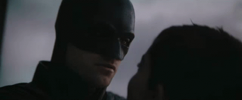 A Close Up Of A Man In A Bat Suit With The Words " The Bat And The Cat " Below Him GIF