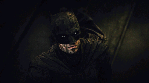 A Close Up Of A Man In A Batman Costume In The Dark GIF