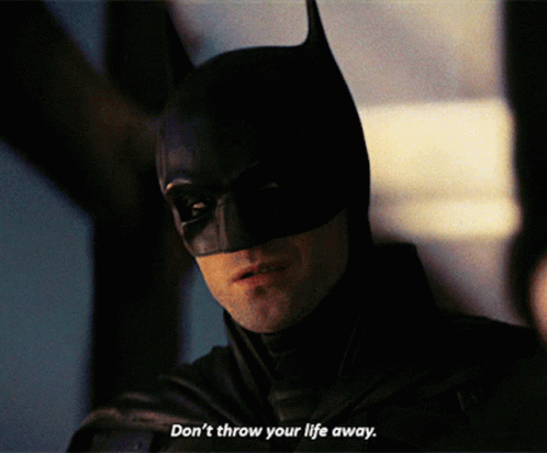 A Close Up Of A Man In A Batman Costume With The Words " Don 'T Throw Your Life Away " GIF