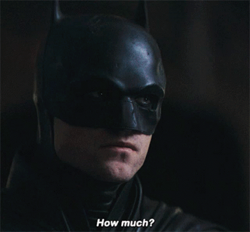 A Close Up Of A Man In A Batman Costume With The Words How Much Below Him GIF