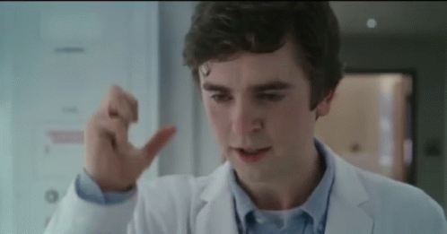 A Close Up Of A Man In A Lab Coat Making A Thumbs Up Sign . GIF