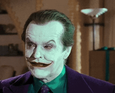 A Close Up Of A Man In A Purple Suit With A Green Shirt And Tie GIF