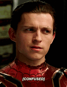 A Close Up Of A Man In A Spiderman Costume With The Word Confused Written On His Face . GIF