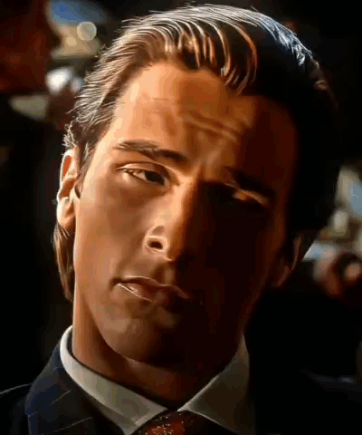 A Close Up Of A Man In A Suit And Tie Looking At The Camera GIF