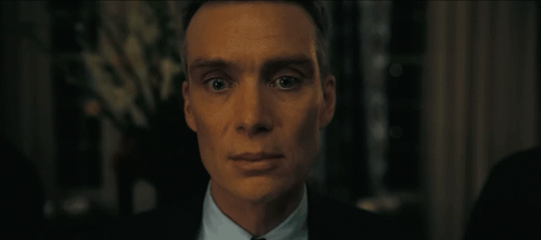 A Close Up Of A Man In A Suit And Tie Looking At The Camera GIF