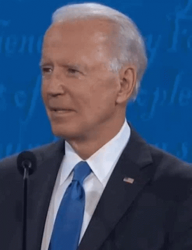 A Close Up Of A Man In A Suit And Tie Talking Into A Microphone . GIF