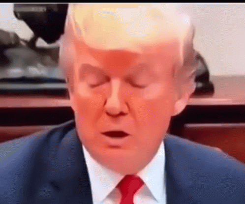 A Close Up Of A Man In A Suit And Tie With His Eyes Closed . GIF