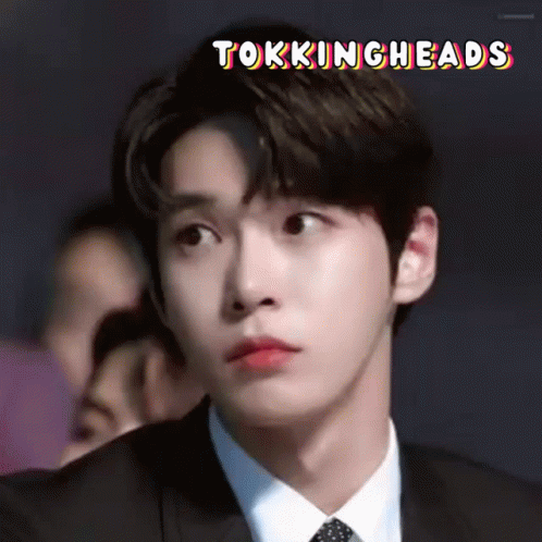 A Close Up Of A Man In A Suit And Tie With The Words Tokingheads Written Above Him . GIF