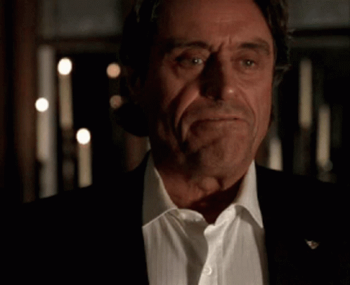 a close up of a man in a suit and white shirt with his eyes closed .