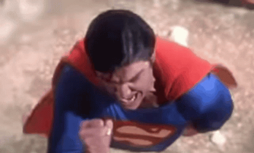A Close Up Of A Man In A Superman Costume Flying Through The Air . GIF
