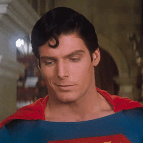 A Close Up Of A Man In A Superman Costume Looking Down GIF