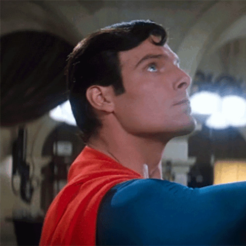 A Close Up Of A Man In A Superman Costume Looking Up GIF