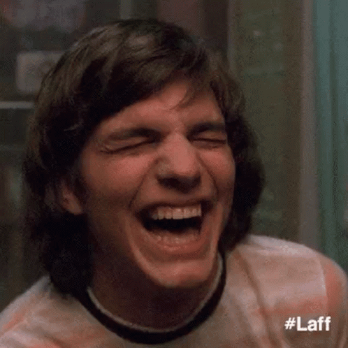 A Close Up Of A Man Laughing With His Eyes Closed And His Mouth Open . GIF