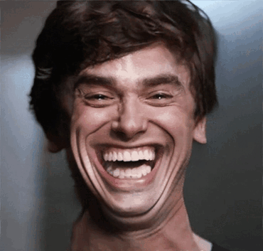 A Close Up Of A Man Laughing With His Mouth Open GIF