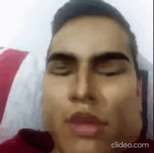 A Close Up Of A Man Laying In Bed With His Eyes Closed . GIF