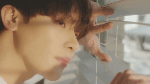 A Close Up Of A Man Looking Out A Window GIF