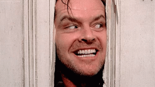 A Close Up Of A Man Looking Through A Door GIF
