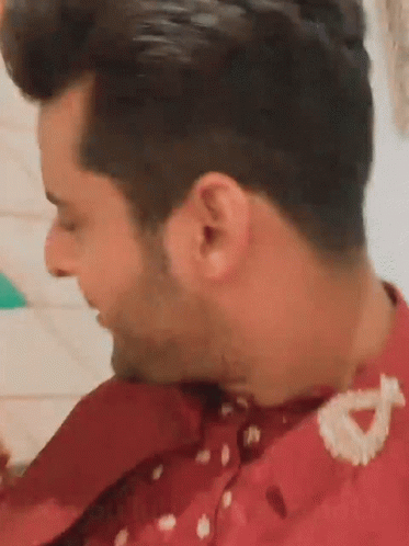 A Close Up Of A Man 'S Ear With A Red Shirt On . GIF