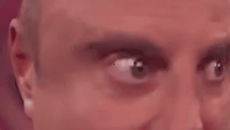 A Close Up Of A Man 'S Eyes Looking At The Camera With A Red Background . GIF