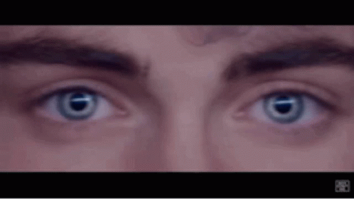 A Close Up Of A Man 'S Eyes With Blue Lenses GIF