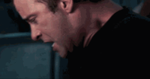 A Close Up Of A Man 'S Face And Neck In A Dark Room GIF