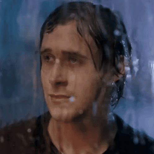A Close Up Of A Man 'S Face Behind A Wet Glass GIF