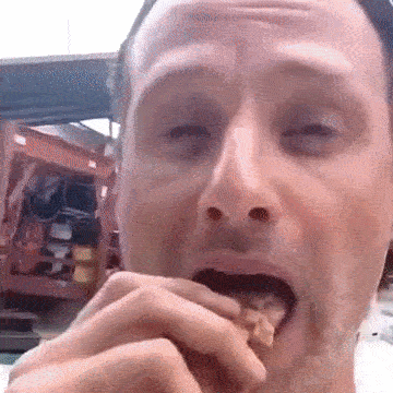 A Close Up Of A Man 'S Face Eating Something GIF
