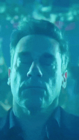 A Close Up Of A Man 'S Face In A Blue Light GIF