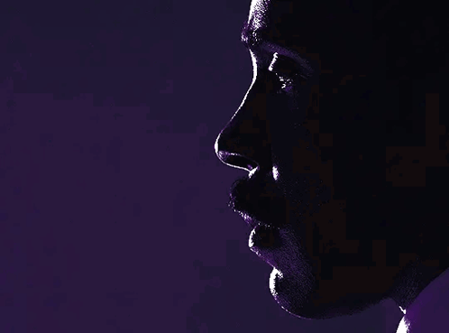a close up of a man 's face in a dark room