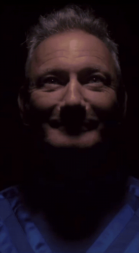 A Close Up Of A Man 'S Face In A Dark Room GIF