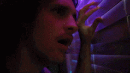 A Close Up Of A Man 'S Face In A Dark Room GIF
