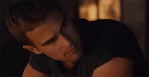 A Close Up Of A Man 'S Face In A Dark Room Looking At The Camera . GIF