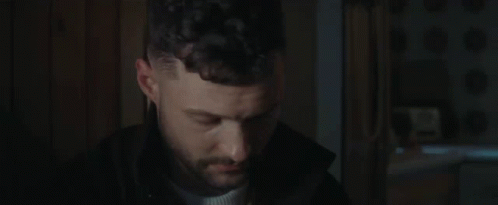 A Close Up Of A Man 'S Face In A Dark Room . GIF