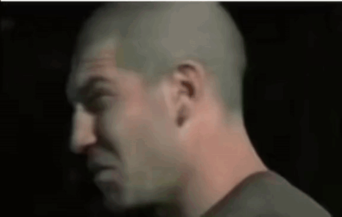 A Close Up Of A Man 'S Face In A Dark Room . GIF